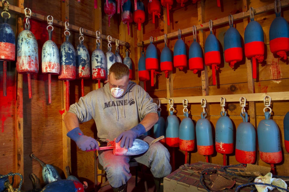 Lobsterman Kendall Delano sands last year's paint off lobster buoys he's painting in his workshop in Friendship, Maine, Thursday, May 10, 2012. Two lobster boats were recently sunk by vandals on Friendship, bringing back memories of territorial tensions in the industry that led to a shooting two summers ago. (AP Photo/Robert F. Bukaty)
