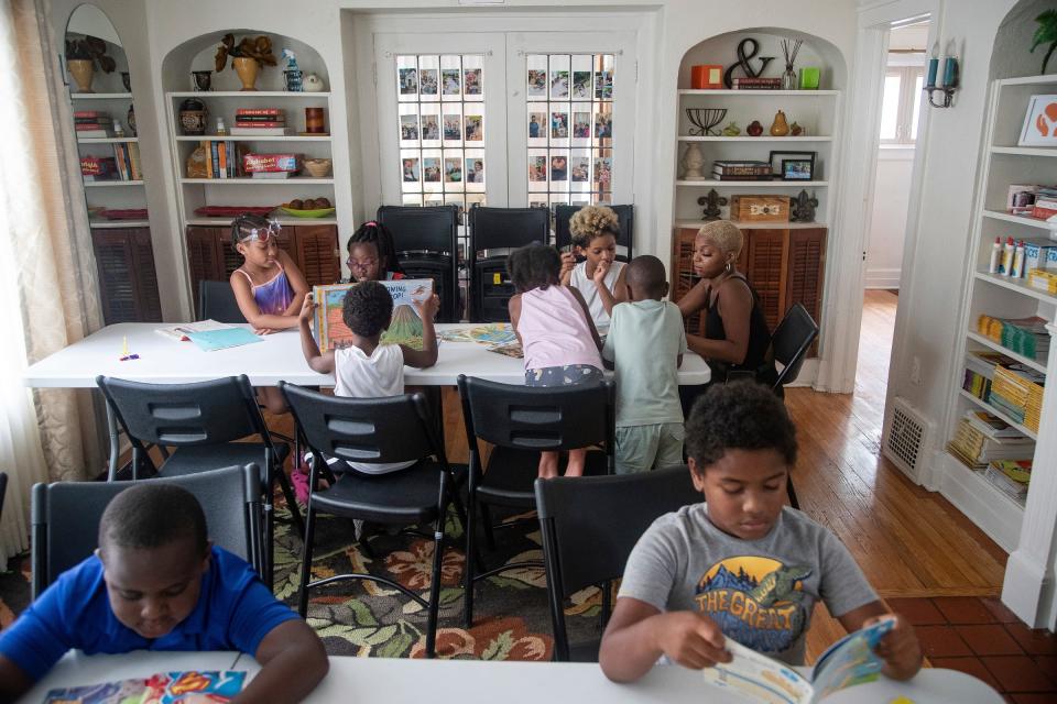 Students read books as parent volunteer Kyra Scandrick reads to some of the students during snack and story time after lunch break in the multi-purpose room at Brilliant Detroit in Detroit on Thursday, August 10, 2023.