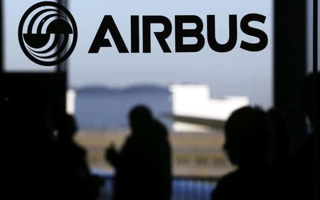 People are silhouetted past a logo of the Airbus Group during the Airbus annual news conference in Colomiers, near Toulouse January 13, 2015. REUTERS/Regis Duvignau