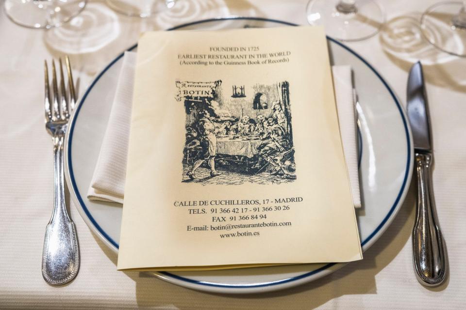 A table setting with a restaurant menu on the plate.