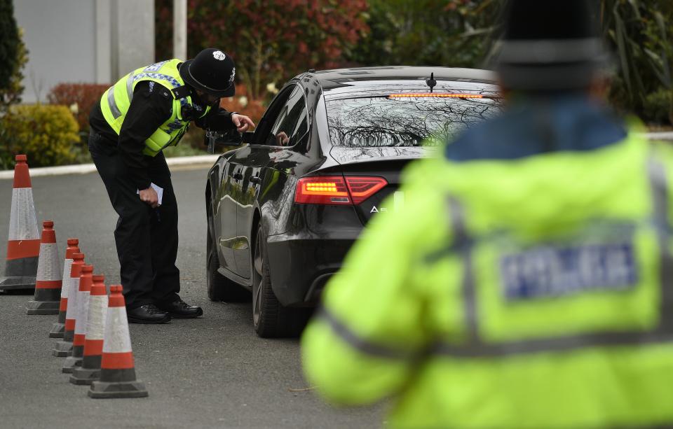 Police officers from North Yorkshire Police stop motorists in cars to check that their travel is "essential", in line with the British Government's Covid-19 advice to "Stay at Home", in York, northern England on March 30, 2020, as life in Britain continues during the nationwide lockdown to combat the novel coronavirus pandemic. - Life in locked-down Britain may not return to normal for six months or longer as it battles the coronavirus outbreak, a top health official warned on Sunday, as the death toll reached passed 1,200. (Photo by Oli SCARFF / AFP) (Photo by OLI SCARFF/AFP via Getty Images)