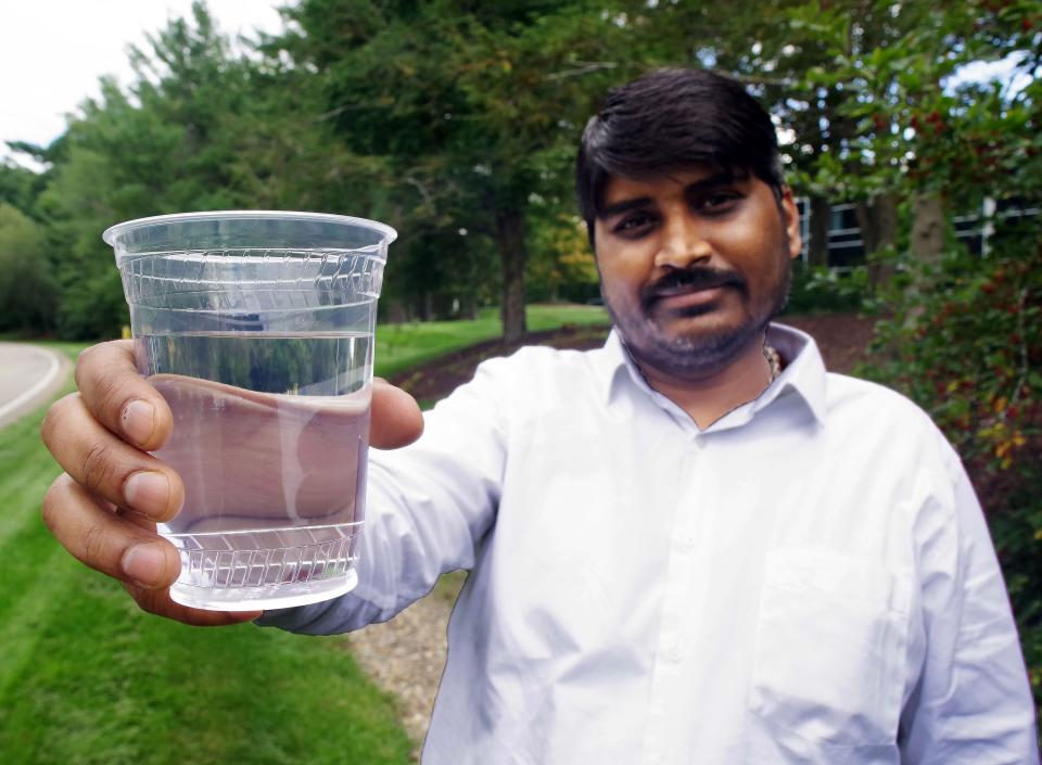 Logesh Chokkalingam of Raynham holds a glass of tap water from Raynham on Wed. Sept., 21, 2022. Chokkalingam, a seven-year resident of Raynham, said he is concerned about elevated levels of PFAS in some Raynham water.