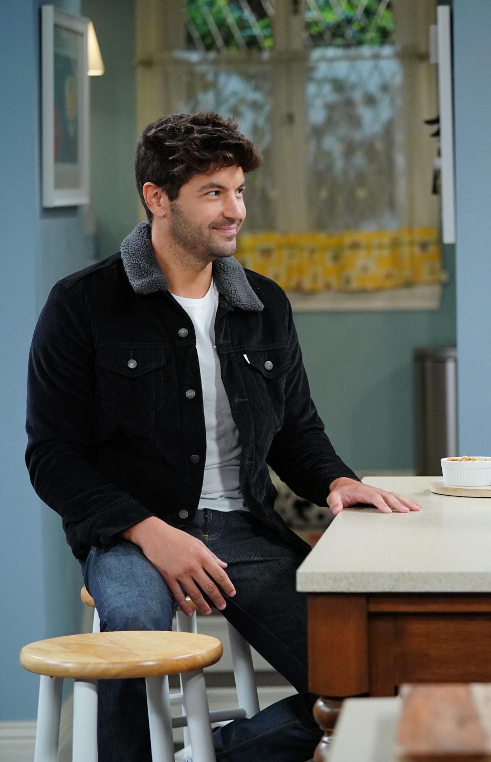 him in the role sitting at a kitchen island