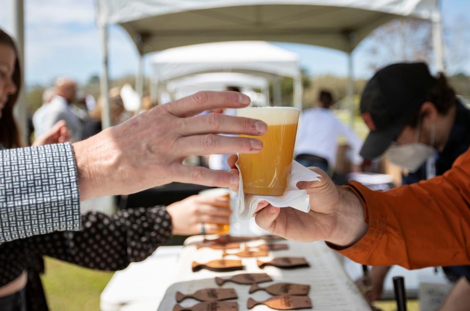 Attendees enjoy samples of wine and beer as well as small bites of food during this year's Cleaver and Cork event at Tallahassee Community College Saturday, March, 6, 2021.