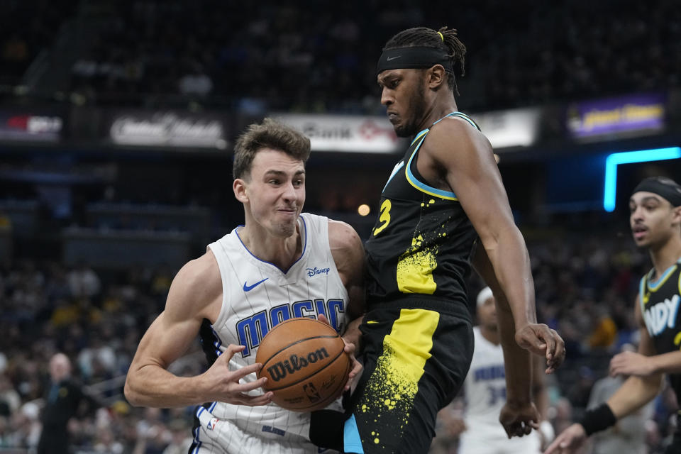 Orlando Magic's Franz Wagner (22) goes to the basket against Indiana Pacers' Myles Turner (33) during the first half of an NBA basketball game Saturday, Dec. 23, 2023, in Indianapolis. (AP Photo/Darron Cummings)