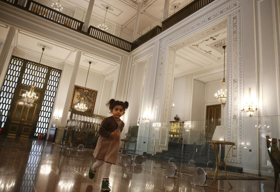 In this Tuesday, Jan. 15, 2019 photo, a girl runs in Niavaran Palace, now a museum, that was the primary and last residence of late Shah Mohammad Reza Pahlavi and his family prior to leaving Iran for exile during the 1979 Islamic Revolution, in northern Tehran, Iran. The palace complex of mansions on a 27-acre plot, nestled against the Alborz Mountains, now welcomes the public to marvel at the luxuries the shah enjoyed as Iran's monarch for nearly four decades. It costs about $1 to enter. (AP Photo/Vahid Salemi)