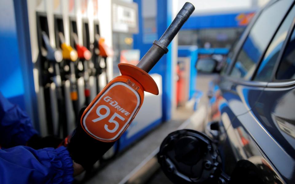 A worker holds a fuel nozzle at a Gazprom Neft petrol station in Moscow - Maxim Shemetov/ REUTERS