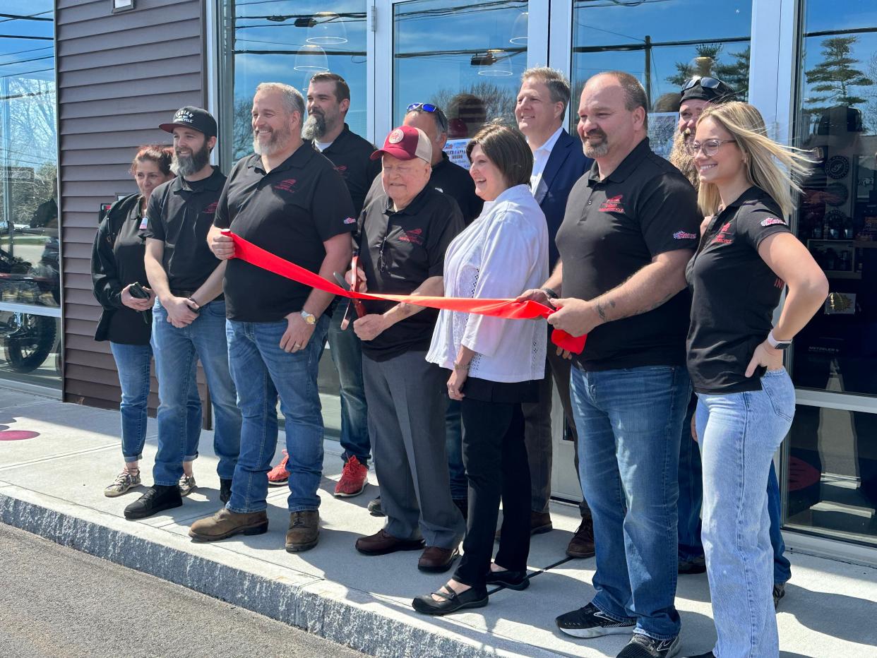 Seacoast Indian Motorcycle owner Richard Nault cuts the ribbon at his new business' opening at 32 Lafayette Road in North Hampton Friday, April 19, joined by his wife, staff and Gov. Chris Sununu.