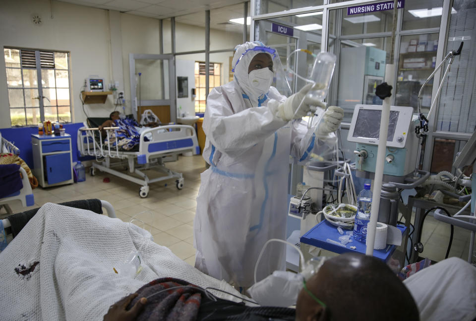 A medical worker attends to a coronavirus patient in the intensive care unit of an isolation and treatment center for those with COVID-19 in Machakos, south of the capital Nairobi, in Kenya Tuesday, Nov. 3, 2020. As Africa is poised to surpass 2 million confirmed coronavirus cases it is Kenya's turn to worry the continent with a second surge in infections well under way. (AP Photo/Brian Inganga)