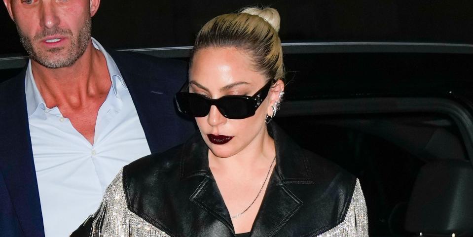 Lady Gaga in a leather jacket with fringe and diamond heels