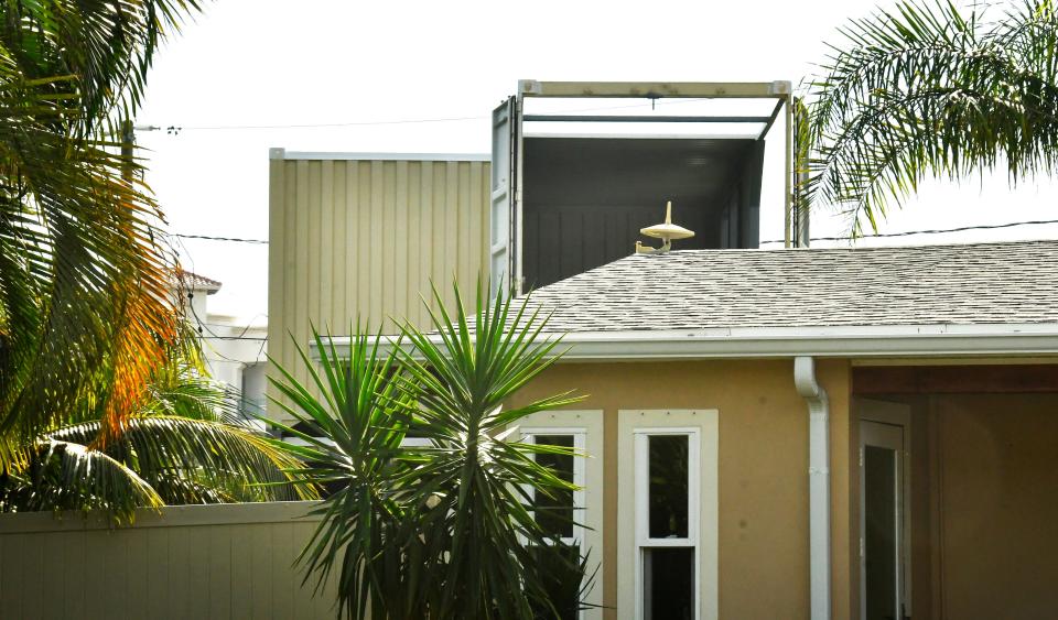 The view from the street shows a part of the stack of containers.. A homeowner on Diane Circle in Indialantic has had several large shipping containers stacked in his backyard, causing complaints from neighbors.