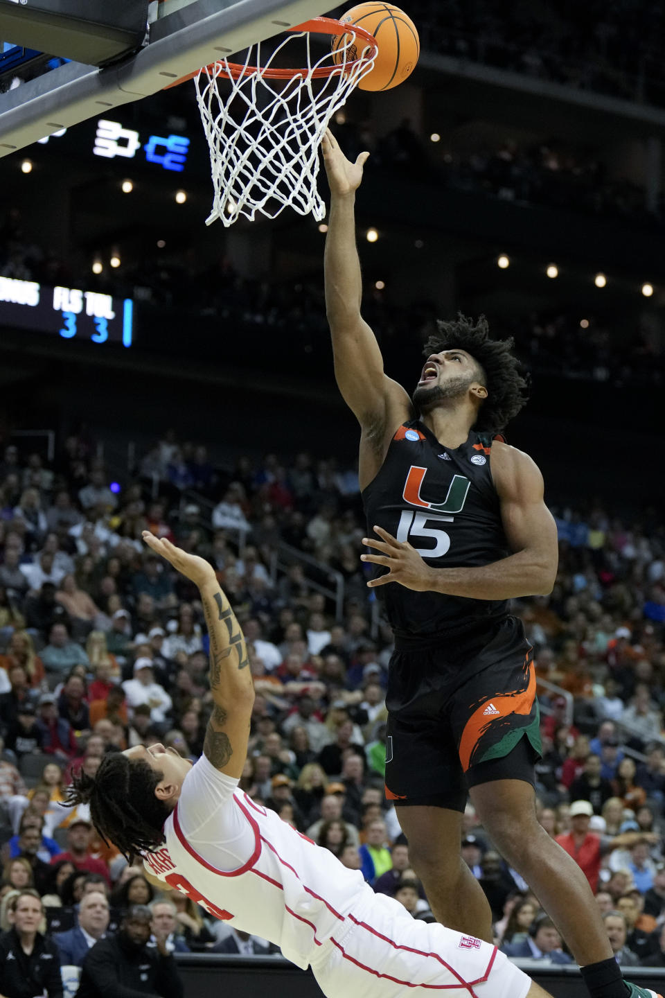 Miami forward Norchad Omier shoots over Houston guard Emanuel Sharp in the first half of a Sweet 16 college basketball game in the Midwest Regional of the NCAA Tournament Friday, March 24, 2023, in Kansas City, Mo. (AP Photo/Jeff Roberson)