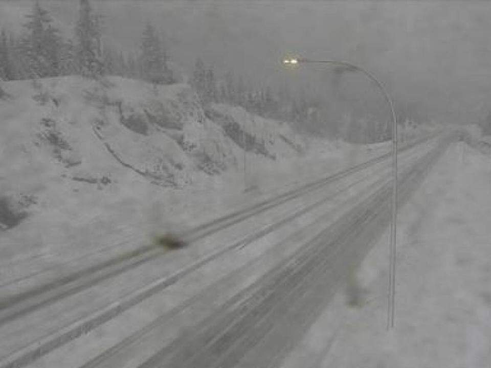 A DriveBC webcam shows snow accumulation on the Coquihalla Highway, south of Merritt, B.C., on Monday. Environment Canada is urging drivers to postpone non-essential travel. (DriveBC - image credit)