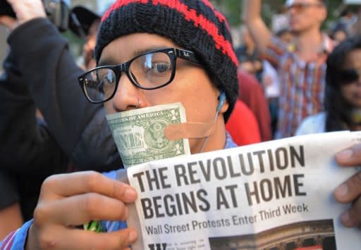 A man with a US dollar bill taped over his mouth joins Occupy Wall Street protesters during a march to Foley Square in New York. Thousands of anti-corporate demonstrators backed for the first time in large numbers by trade unions poured into New York's financial district Wednesday, raising the stakes in a more than two-weeks long street revolt