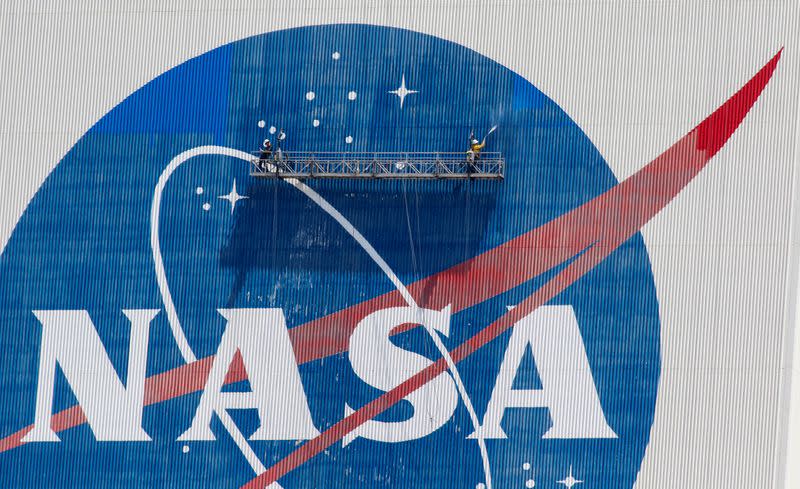 FILE PHOTO: Workers pressure wash the logo of NASA on the Vehicle Assembly Building, in Cape Canaveral