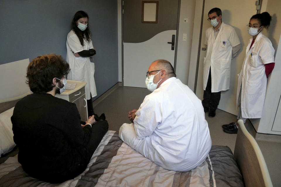 Psychiatrist Olivier Guillin, center, talks with Nathan, a 22-year-old student, at the Rouvray psychiatric hospital, in Rouen, western France, Wednesday, Nov. 25, 2020. Lockdowns that France has used to fight the coronavirus have come at considerable cost to mental health. Surveying points to a surge of depression most acute among people without work, in financial hardship and young adults. (AP Photo/Thibault Camus)