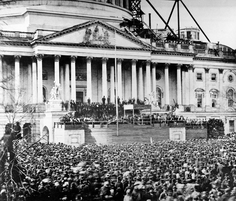 In this March 4, 1861 file photo, President Abraham Lincoln stands under cover at the center of the Capitol steps during his inauguration in Washington. The scaffolding at the upper right is used in the construction of the Capitol dome.