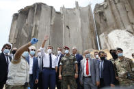 FILE - In this Aug. 6, 2020, file photo, French President Emmanuel Macron, center left, gestures as he visits the devastated site of the explosion at the port of Beirut, Lebanon. In the wake of Beirut's massive port explosion, Macron has taken a tough line, setting deadlines for Lebanon's politicians to carry out reforms. His hands-on approach has angered some in Lebanon and brought praise from others. (AP Photo/Thibault Camus, Pool, File)