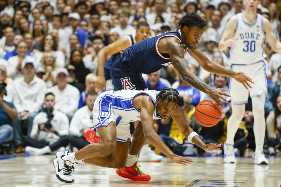 Arizona guard KJ Lewis, top, and Duke guard Jeremy Roach, bottom, dive for the ball during the first half of an NCAA college basketball game in Durham, N.C., Friday, Nov. 10, 2023. (AP Photo/Nell Redmond)