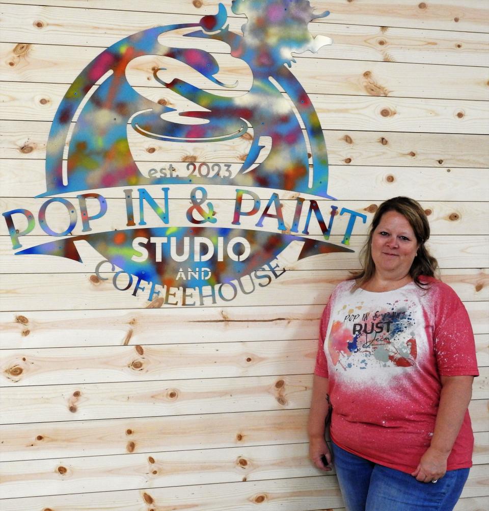 Jill Sheridan of Rust Décor in front of the sign for the new Pop in & Paint Studio and Coffeehouse that will be added to the store upcoming. Rust Décor recently had a ribbon cutting and grand opening at its new location at 341 Main St.