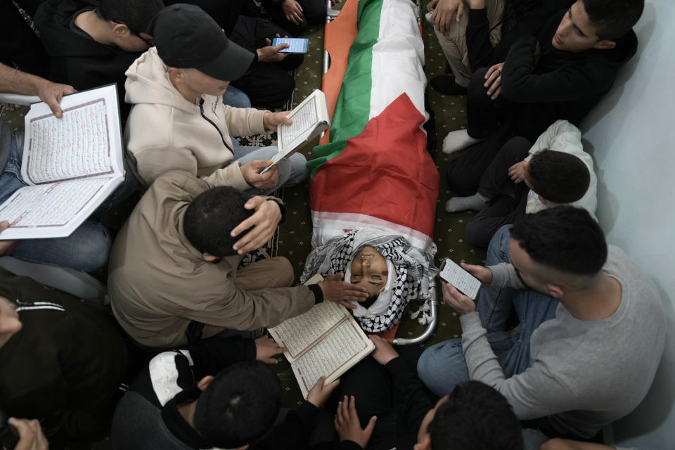 Mourners pray as they gather around the body of Mutasim Abu Abed, 13, during his funeral in Qabatiya, near the West Bank city of Jenin, Saturday, March 30, 2024. Dr. Fawaz Hamad, director of Al-Razi Hospital in Jenin, told local station Awda TV that Israeli forces killed a 13-year-old boy in nearby Qabatiya early Saturday. Israel's military said the incident was under review. (AP Photo/Majdi Mohammed)