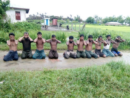 Ten Rohingya Muslim men with their hands bound kneel in Inn Din village, Myanmar, September 1, 2017. Handout via REUTERS