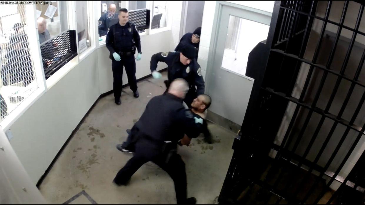 Elkhart officers Joshua Titus, wearing cap, and Cory Newland punch Mario Guerrero Ledesma to the floor inside the city police station in January.