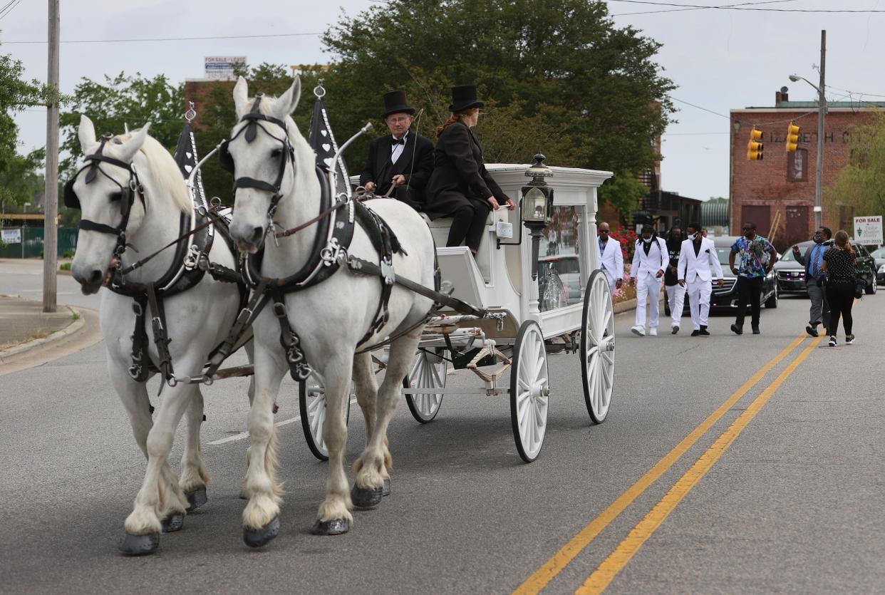 Family and friends follow behind a horse drawn carriage bringing the remains of Andrew Brown Jr. to his funeral service at the Fountain of Life church on May 3, in Elizabeth City, N.C.
