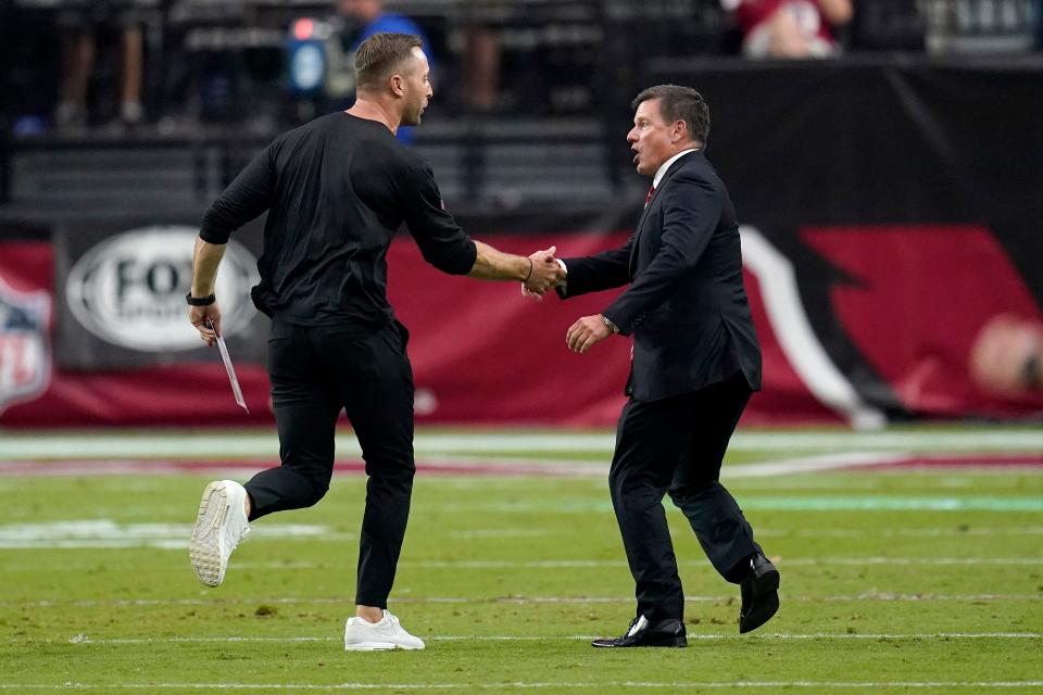 Arizona Cardinals head coach Kliff Kingsbury, left, greets team president Michael Bidwill after an NFL football game against the Minnesota Vikings, Sunday, Sept. 19, 2021, in Glendale, Ariz. The Cardinals won 34-33. (AP Photo/Ross D. Franklin)