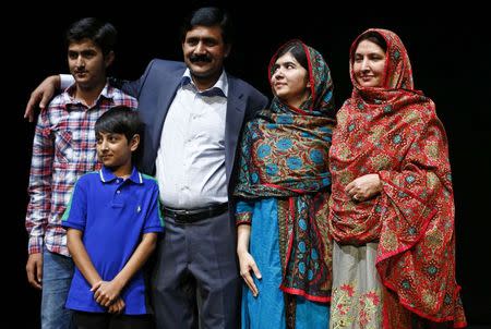 Pakistani schoolgirl Malala Yousafzai (2nd R), the joint winner of the Nobel Peace Prize, stands with her father Ziauddin (C), mother Torpekai (R), and brothers Atal (2nd L) and Khushal, after speaking at Birmingham library in Birmingham, central England October 10, 2014. REUTERS/Darren Staples