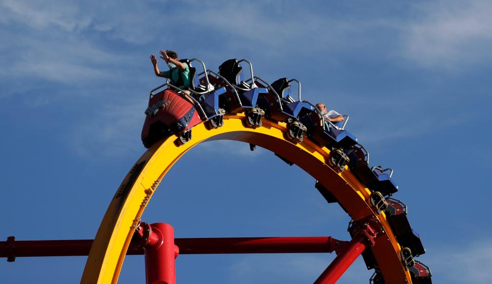 Visitors to Six Flag Fiesta Texas wear masks for protection against the coronavirus and are spaced apart on a ride Friday, the day it reopened in San Antonio. Multiple counties and cities in Texas are ordering businesses to require customers and workers to wear face masks as the state sees a continued rise in the numbers of new coronavirus cases and hospitalizations.