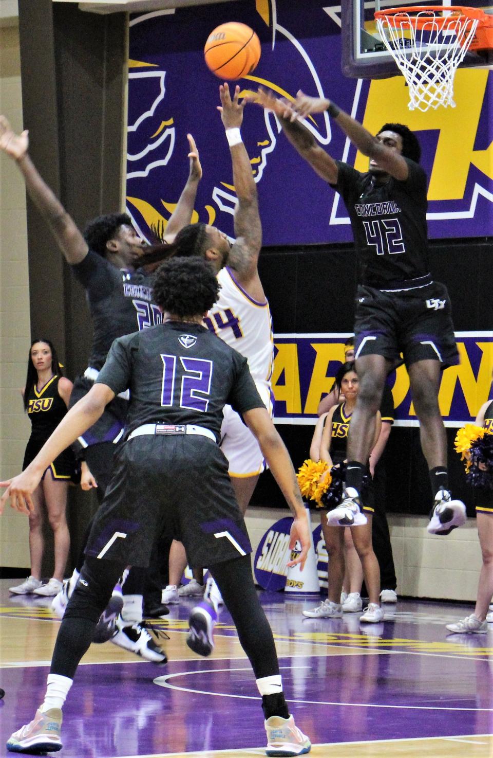 HSU's Steven Quinn (14) shoots over the leaping defense of Concordia's Robert Hall in the second half of their American Southwest Conference quarterfinal game Tuesday at the Mabee Complex. The Cowboys won 101-96, beating the Tornados for the third time this year - scoring 100 points or more each game.