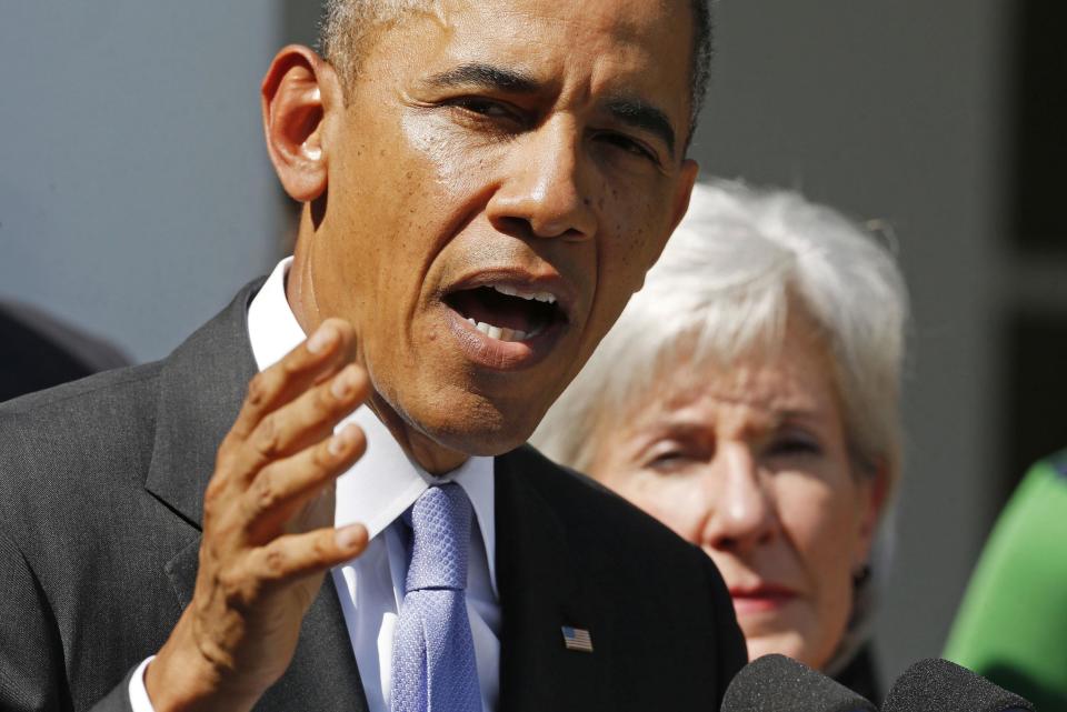 U.S. President Barack Obama delivers remarks alongside Human Services Secretary Kathleen Sebelius (R) and other Americans the White House says will benefit from the opening of health insurance marketplaces under the Affordable Care Act, in the Rose Garden of the White House in Washington, October 1, 2013. The U.S. government began a partial shutdown on Tuesday for the first time in 17 years, potentially putting up to 1 million workers on unpaid leave, closing national parks and stalling medical research projects. October 1, 2013. REUTERS/Larry Downing (UNITED STATES - Tags: POLITICS BUSINESS HEALTH)