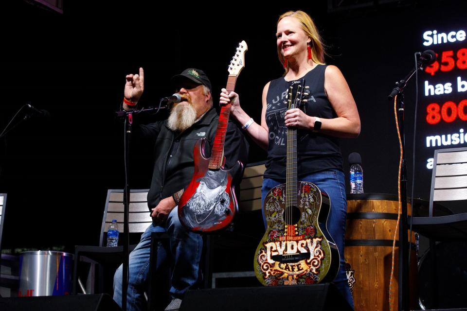 Red Dirt Relief Fund Executive Director Katie Dale, right, appears onstage during the guitar auction at the 2022 Bob Childers' Gypsy Cafe in Stillwater.