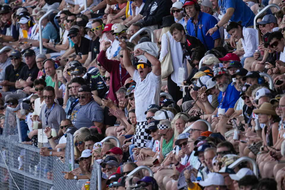 A fan, center, cheers during the running of the Indianapolis 500 auto race at Indianapolis Motor Speedway in Indianapolis, Sunday, May 26, 2024. (AP Photo/AJ Mast)