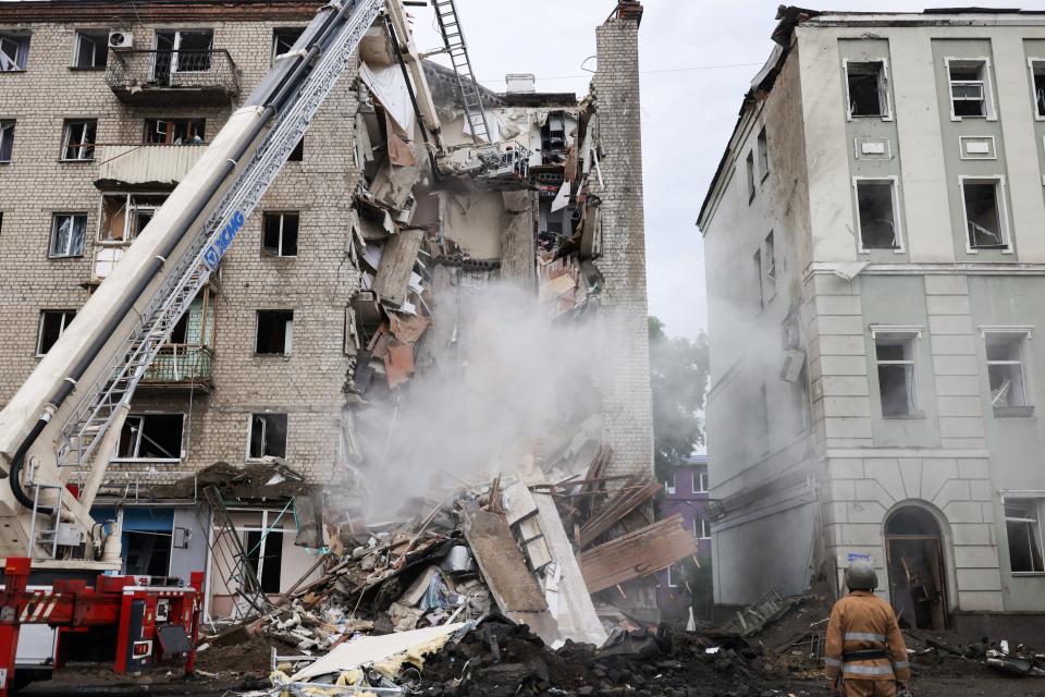 Firefighters remove debris after a military strike hit a building in Kharkiv on Monday (REUTERS/Nacho Doce)