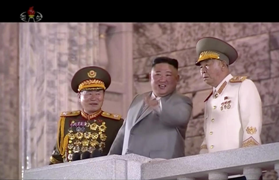 In this image made from video broadcasted by North Korea's KRT, North Korean leader Kim Jong Un, center, watches military parade during a ceremony to celebrate the 75th anniversary of the country’s ruling party in Pyongyang Saturday, Oct. 10, 2020.(KRT via AP)