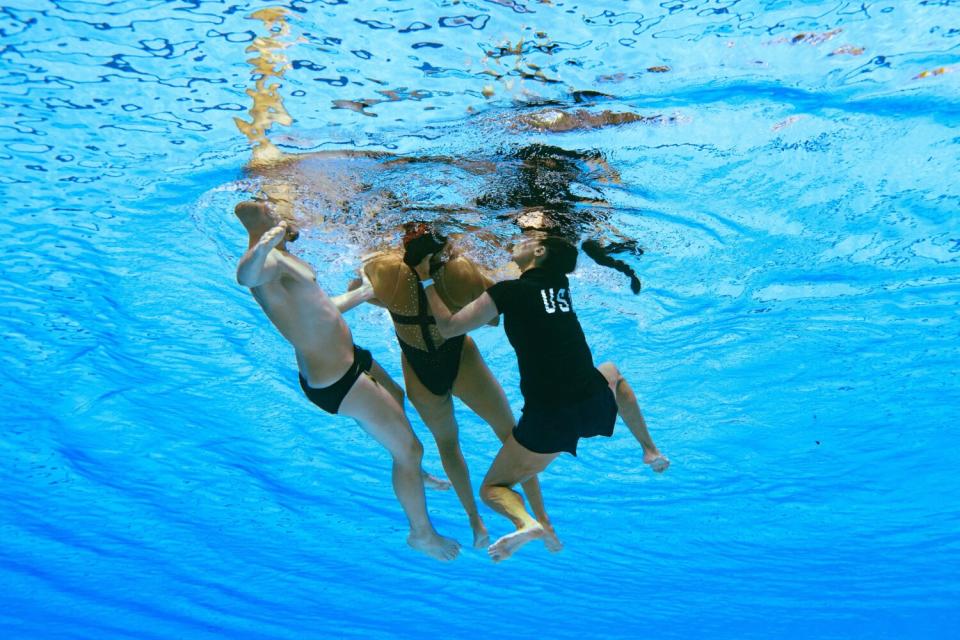 USA coach Andrea Fuentes, right, recovers USA's Anita Alvarez from the bottom of the pool