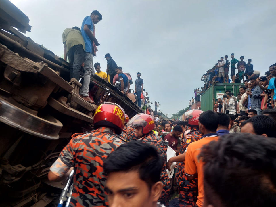 This photograph provided by the Bangladesh Fire Service and Civil Defense Department shows rescuers and others after a cargo train hit a passenger train at Bhairab, Kishoreganj district, Bangladesh, Monday, Oct.23, 2023. More than a dozen people are killed and scores more are injured according to fire officials. (Bangladesh Fire Service and Civil Defense Department via AP)