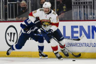 Florida Panthers' Aleksander Barkov (16) moves the puck past Tampa Bay Lightning's Ondrej Palat (18) during the first period of an NHL preseason hockey game, Tuesday, Oct. 5, 2021, in Orlando, Fla. (AP Photo/John Raoux)