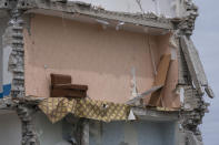 A sofa chair is seen in what is left standing in the aftermath of a Russian rocket that hit an apartment residential block, in Chasiv Yar, Donetsk region, eastern Ukraine, Sunday, July 10, 2022. At least 15 people were killed and more than 20 people may still be trapped in the rubble, officials said Sunday. (AP Photo/Nariman El-Mofty)