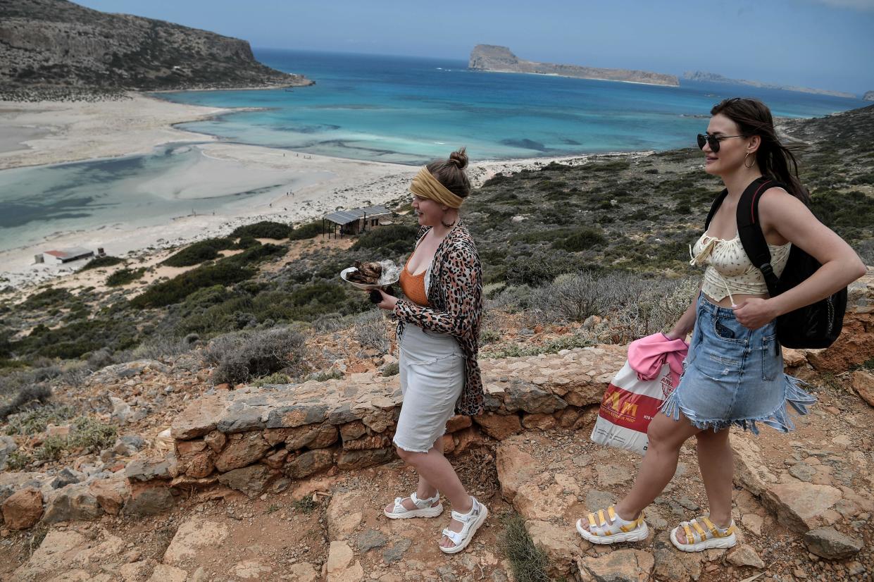Tourists carry their meals as they walk towards the Balos beach and its lagoon on the north-eastern part of the island of Crete, Greece. Photo: Louisa Gouliamaki/AFP via Getty Images