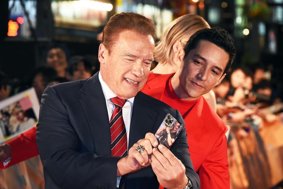 Arnold Schwarzenegger poses for a selfie with a fan in Tokyo on Wednesday, revealing that he has a phone case that is a photo of himself from the original <i>Terminator</i>. 