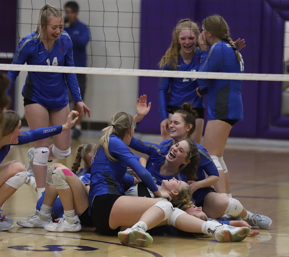 Holy Trinity players pile on the floor in celebration after a 3-1 victory over Notre Dame in a Class 1A regional final Wednesday in Burlington. Holy Trinity advances to the state tournament next week.