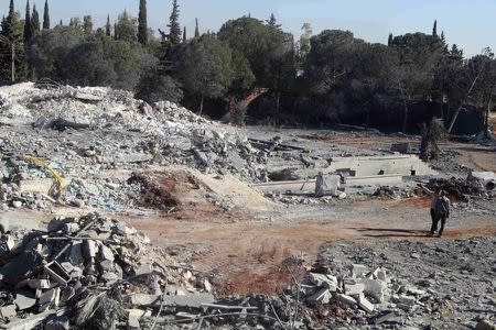 Men inspect damage of collapsed buildings after what activists said was a U.S.-led air strike on Kafar Joum village in West Aleppo countryside November 6, 2014. REUTERS/Stringer