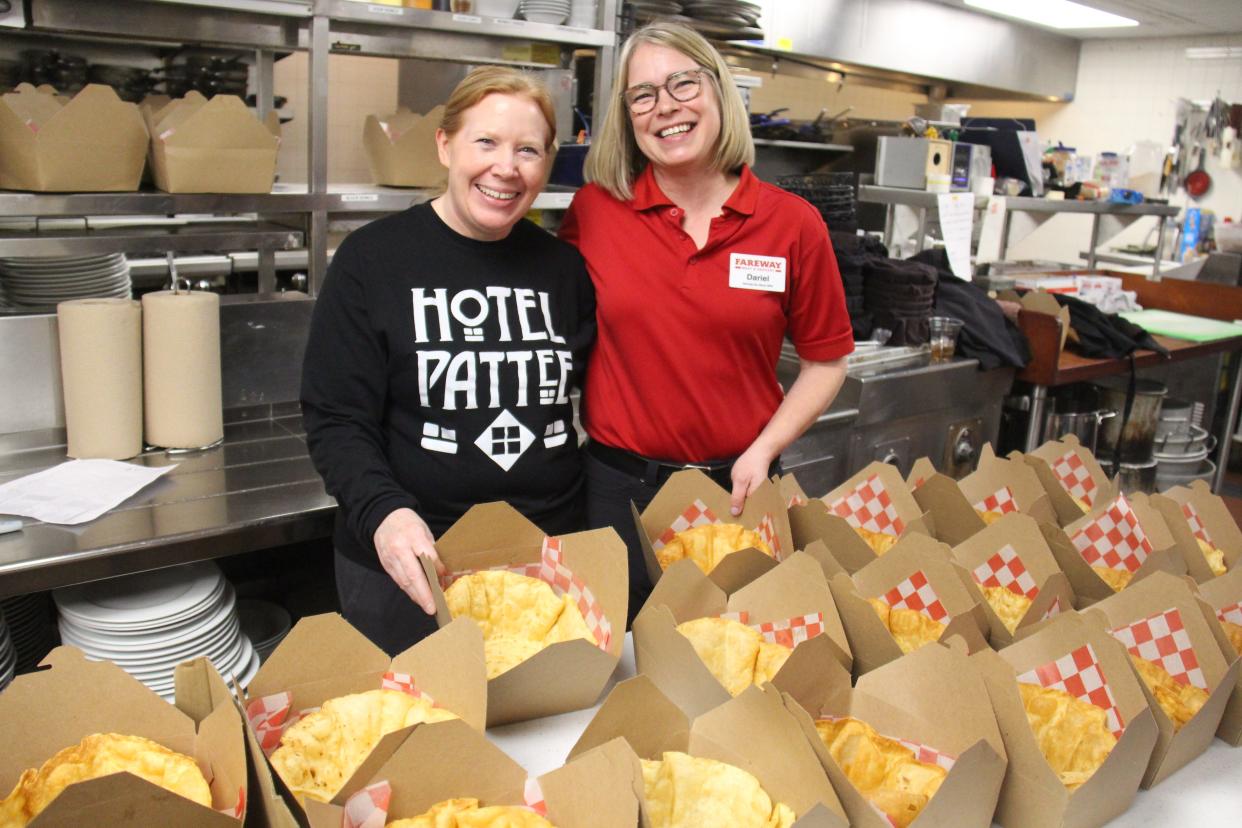 Angie Petersen, left, and Dariel McNamara pose for a photo while assembling taco salads at the Hotel Pattee on Thursday, March 16.