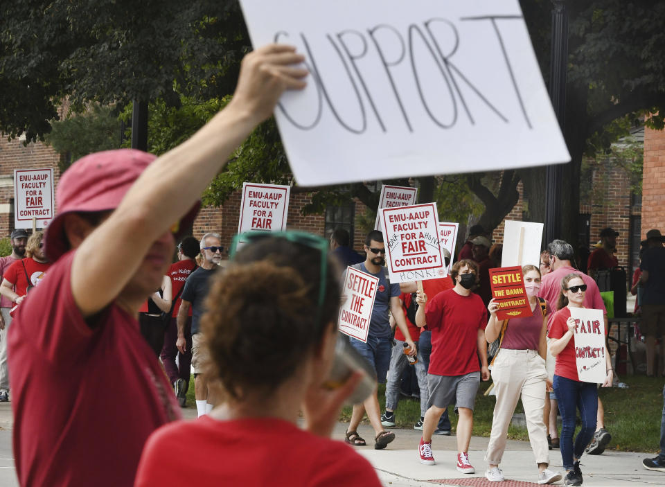 Picketing professors and their supporters hold signs in front of Welch Hall at Eastern Michigan University in Ypsilanti, Mich., on Wednesday, Sept. 7, 2022. Several dozen faculty at Eastern Michigan University began a strike Wednesday after their union and the school's administration failed to agree on a new labor contract. (Daniel Mears/Detroit News via AP)