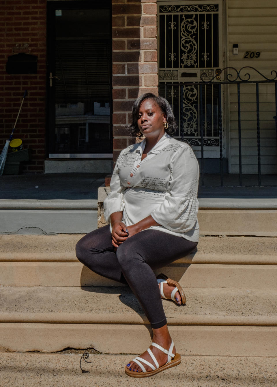 Portrait of April Lee in front of her home in Philadelphia. (Stephanie Mei-Ling for NBC News and ProPublica)