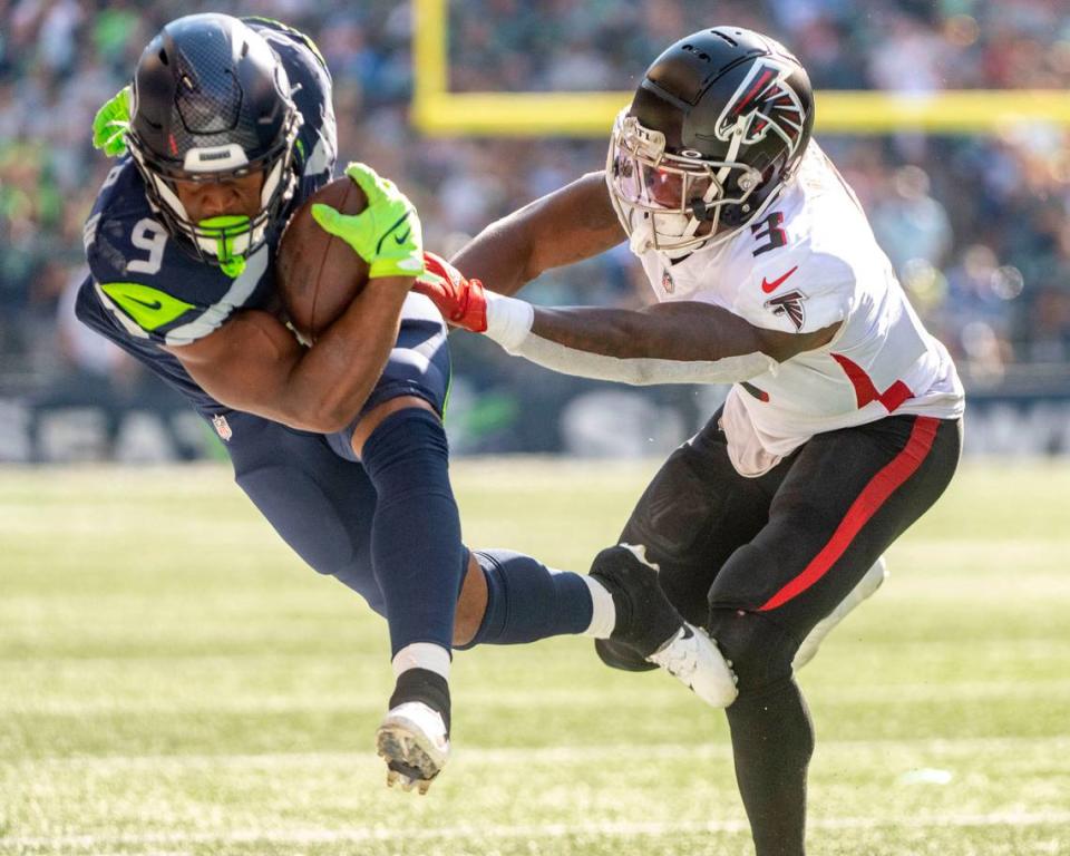 Seattle Seahawks running back Kenneth Walker III (9) gets pushed out of bounds by Atlanta Falcons linebacker Mykal Walker (3) during the third quarter of an NFL game on Sunday, Sept. 25, 2022, at Lumen Field in Seattle.