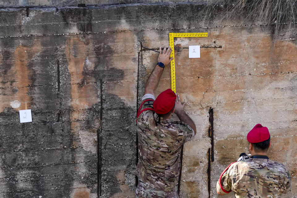 Lebanese Army investigators inspect bullet holes and collect forensic evidence next to the entrance of U.S. Embassy in Aukar, a northern suburb of Beirut, Lebanon, Thursday, Sept. 21, 2023. Lebanon's security agencies have launched an investigation into a late night shooting outside the U.S. embassy in Lebanon that caused no injuries, officials said Thursday. (AP Photo/Hassan Ammar)